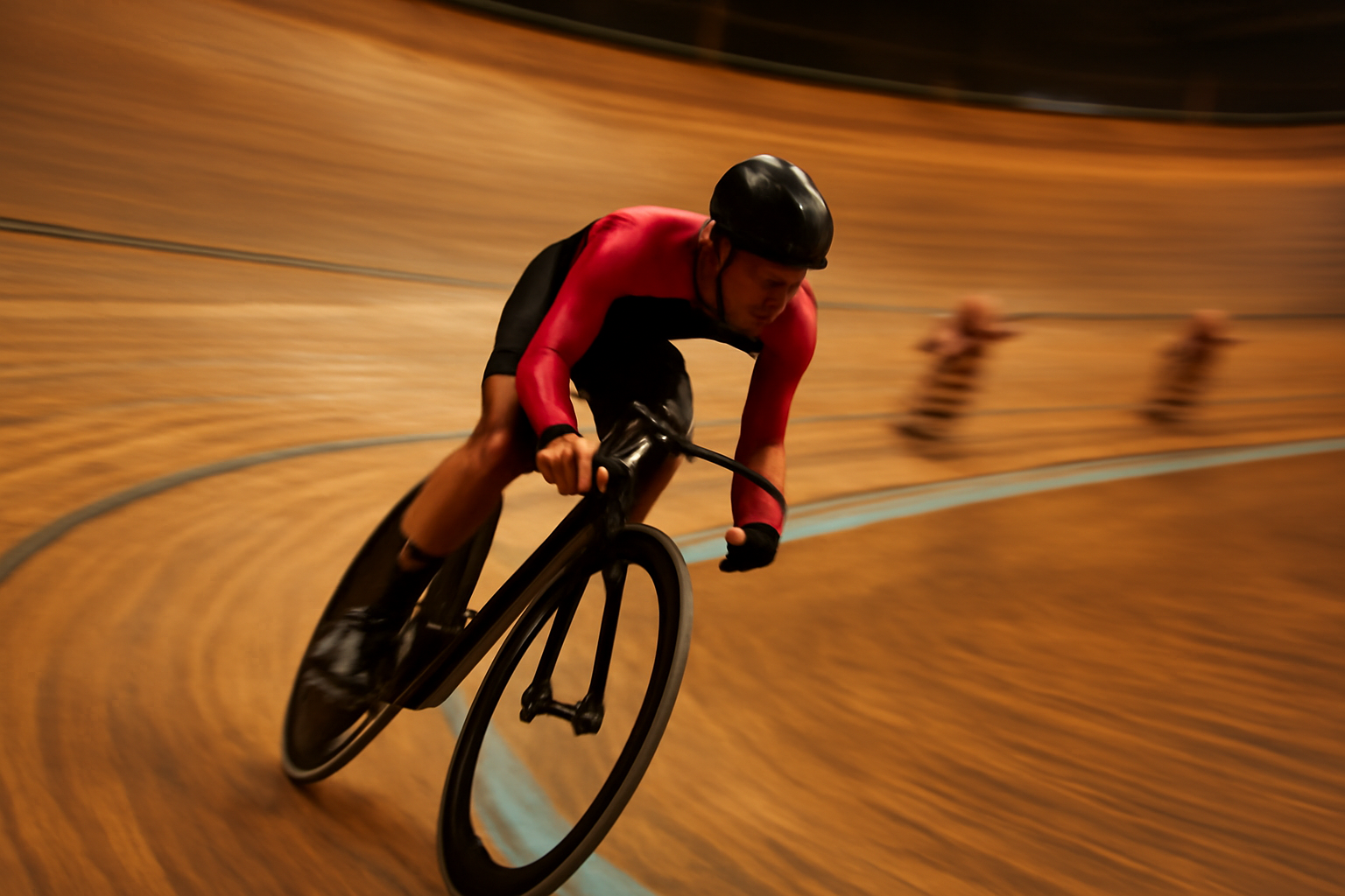 Pesepeda trek memacu sepeda di tikungan velodrome saat latihan sprint